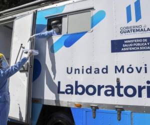 Se ve a trabajadores de salud en un laboratorio móvil para realizar pruebas de Covid-19 en el mercado de Guarda en la Ciudad de Guatemala el 13 de enero de 2021. - Guatemala desplegó laboratorios móviles en tres mercados importantes de la capital el miércoles para tomar muestras de covid-19 en respuesta. al recrudecimiento del contagio en el país en los últimos días. (Foto de ORLANDO ESTRADA / AFP)