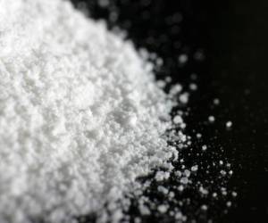 A heap of white powder on black floor.