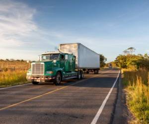 Trucks driving along the Panamericana Highway in Costa Rica close to the border of Nicaragua in the late afternoon light. Motion Blured, Panning. Nicaragua-Costa Rica Panamericana, Central America