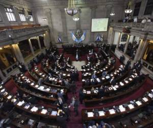 Guatemalan deputies attend a session of the Congress to vote to maintain or not the immunity of Guatemalan President Jimmy Morales accused of corruption in Guatemala City on September 11, 2017.Guatemala's congress on Monday voted overwhelmingly to reject a UN-backed request to lift the immunity of President Jimmy Morales in order for him to face a corruption probe over irregular campaign financing. Only 25 lawmakers voted in favor of the motion to strip Morales of his immunity, far fewer than the 105 needed in the 158-member legislature. / AFP PHOTO / JOHAN ORDONEZ
