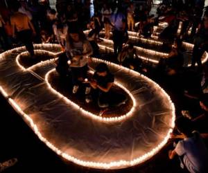 Decenas de personas encienden velas en Cali, Colombia para formar el 60+ sel símbolo de la hora de la Hora del Planeta.
