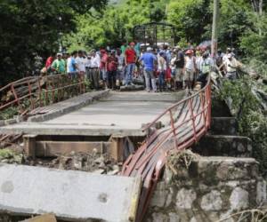 Residents of Teustepe stand by the Malacatoya bridge, destroyed by heavy rains in the Pacific Coast, in Boaco, some 60km from Managua, on October 26, 2017. / AFP PHOTO / INTI OCON