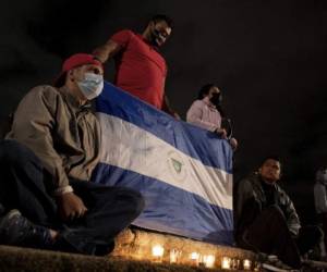 Nicaraguan exiles living in Costa Rica participate in a vigil against the Nicaraguan government and President Daniel Ortega, in San Jose, Costa Rica, January 9, 2022. - Ortega, 76, was reelected on November 7, 2021 to a fourth consecutive term with 75 percent of the vote but the result was largely rejected by the international community, including the United States and European Union. Since returning to power in 2007, he has become increasingly authoritarian and quashed presidential term limits. (Photo by Ezequiel BECERRA / AFP)
