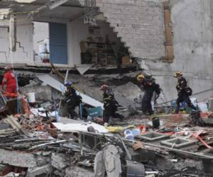 Rescue workers evacuate the place where they were working after a seismic alert sounded in Mexico City on September 23, 2017, four days after the powerful quake that hit central Mexico.In the capital, the quake toppled 39 buildings, mostly in a central area with older construction that is popular with tourists and foreigners living in the city, and also in the south. / AFP PHOTO / PEDRO PARDO