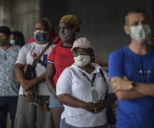 People wait to enter a supermarket wearing face masks amid concern over the spread of the COVID-19 coronavirus, in Panama City, on June 1, 2020. - Panama's government reopened on Monday the construction, non-metallic mining and industry sectors, which were inactive to combat covid-19, in an attempt to 'avoid the economic collapse' of the country with the largest number of infections in Central America. (Photo by Luis ACOSTA / AFP)