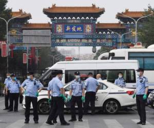 Chinese police guard the entrance to the closed Xinfadi market in Beijing on June 13, 2020. - Eleven residential estates in south Beijing have been locked down due to a fresh cluster of coronavirus cases linked to the Xinfadi meat market, officials said on June 13. (Photo by GREG BAKER / AFP)