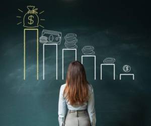 Business woman standing in front of a blackboard with a financial chart