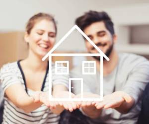 Young couple holding their new, dream home in hands