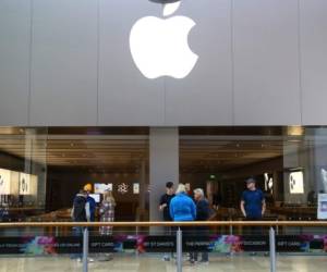 Staff speak to customers at the entrance to a closed Apple store in Cardiff, Wales on March 14, 2020. - Apple is closing all of its stores outside China until March 27 in a bid to slow the spread of the new coronavirus outbreak, CEO Tim Cook announced late March 13, 2020. Cook said the firm had learned from steps taken in China, where the tech giant has just reopened its retail stores. (Photo by GEOFF CADDICK / AFP)