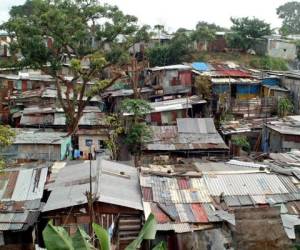 Fotografía tomada el 21 de julio de 2004 del sector conocido como las 'Cuencas de Guararí', en la zona sur de la provincia de Heredia (norte), terrenos estatales en los cuales corren muchas de las aguas negras de las localidades aledañas y donde se han asentado unas 45.000 personas, el 80% de origen nicaragüense. Los gobiernos de Costa Rica y Nicaragua impulsan conjuntamente un plan piloto que pretende solucionar el problema de vivienda a miles de habitantes de este precario levantado a lo largo de malolientes riachuelos y en condiciones insalubres. AFP PHOTO/Mayela LOPEZ