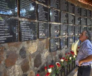 An man reads the names of the victims of the El Mozote massacre at the memorial in the village of El Mozote, 200 km east of San Salvador, on August 30, 2018. Judges of the Inter-American Court of Human Rights (IACHR), whose 59 special session is being held in El Salvador, moved to El Mozote to supervise the compliance with the redress ruled for the largest massacre in recent history in Latin America, in which almost a thousand people were executed by the army in 1981. / AFP PHOTO / Oscar Rivera