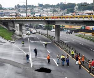 Vista de un agujero gigante en una carretera causado por el colapso de una red de drenaje por las fuertes lluvias que afectaron al país, en Villa Nueva, 15 km al sur de Ciudad de Guatemala el 14 de junio de 2022. Johan ORDÓNEZ / AFP