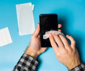 Man cleaning phone screen to apply protective tempered glass