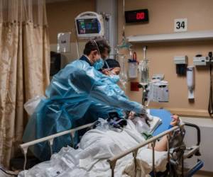 (FILES) In this file photo taken on January 11, 2021 health care workers tend to a Covid-19 patient in a Covid-19 holding pod at Providence St Mary Medical Center in Apple Valley, California. - More than 25 million Covid-19 cases have been recorded in the United States since the pandemic began, Johns Hopkins University said on January 24, 2021, just days after President Joe Biden's inauguration. The milestone was reached only five days after the US, the world's wealthiest and hardest-hit nation, recorded 400,000 deaths from the disease. (Photo by ARIANA DREHSLER / AFP)