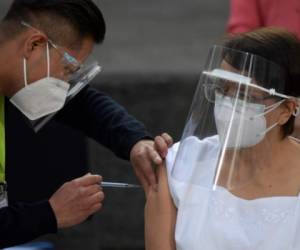 Mexico's nurse Irene Ramirez receives the first of two Pfizer/BioNTech Covid-19 vaccine jabs, at the General Hospital in Mexico City, on December 24, 2020. - Mexico's government started inoculations on Thursday after the first 3,000 doses produced by US pharmaceutical giant Pfizer and its German partner BioNTech arrived by courier plane from Belgium. (Photo by PEDRO PARDO / AFP)