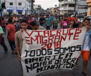 Central American migrants taking part in a caravan called 'Migrant Viacrucis' towards the United States hold a banner reading 'Emigrant Viacrucis 2018. We are all America. No to discrimination' as they march to protest against US President Donald Trump's policies in Matias Romero, Oaxaca State, Mexico, on April 3, 2018. The hundreds of Central Americans in the 'Way of the Cross' migrant caravan have infuriated Trump, but they are not moving very fast -- if at all -- and remain far from the US border. As Trump vowed Tuesday to send troops to secure the southern US border, the caravan was camped out for the third straight day in the town of Matias Romero, in southern Mexico, more than 3,000 kilometers (1,800 miles) from the United States. / AFP PHOTO / VICTORIA RAZO
