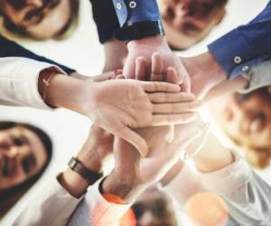 Cropped shot of a group of businesspeople putting their hands together in a huddle