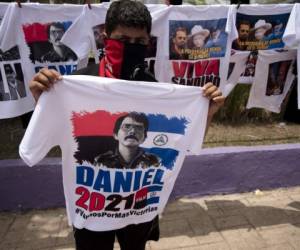 A street vendor shows a T-shirt depicting Nicaraguan President Daniel Ortega, who will run for reelection on 2021, at a bus stop in Managua on July 17, 2020, amid the new coronavirus pandemic. - Nicaragua will celebrate on Sunday the 41st anniversary of the Sandinista Revolution, for the first time without a public event for the speech of Nicaraguan President Daniel Ortega due to the COVID-19 pandemic. (Photo by Maynor Valenzuela / AFP)