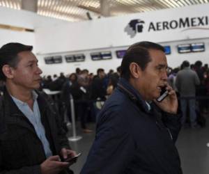 Pasajeros afectados por la huelga de pilotos de Aeromexico llaman tras la cancelación de su vuelo. El paro comenzó tras el despido de un piloto que supuestamente fue obligado a volar con un tumor en la nuca. AFP PHOTO / Pedro PARDO