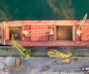 Top view from drone of a large ship loading grain for export. Water transport