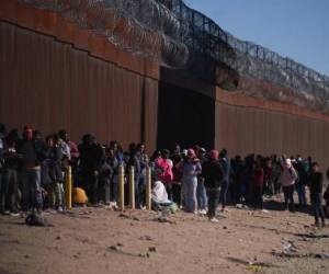 Hundreds of migrants line up to be processed by US Border Patrol under the Stanton Street Bridge after illegally entering the US, in El Paso, Texas, on December 22, 2022. (Photo by Allison Dinner / AFP)