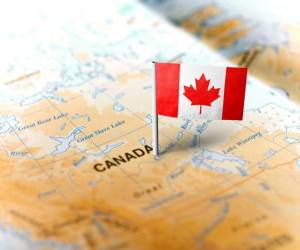 The flag of Canada pinned on the map. Horizontal orientation. Macro photography.