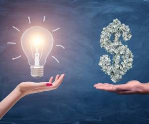 A female and a male hands holding a large bright light bulb and a dollar sign made of many money bills. Money and wealth. Profitable ideas. Financial streak.