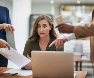 Shot of a young businesswoman looking anxious in a demanding office environment