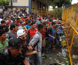 Central Americans, part of a caravan trying to reach the U.S., confront the riot police to break through the border gate to cross into Mexico and carry on their journey, in Tecun Uman, Guatemala, October 28, 2018. REUTERS/Carlos Garcia Rawlins