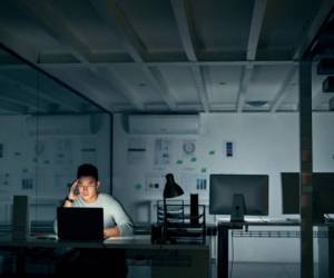 Shot of a young businessman looking stressed during a late night in a modern office