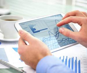 Close-up of businessman using tablet computer to work with financial data