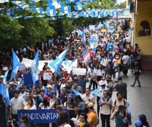 University students take part in a march to demand the resignation of Guatemalan President Jimmy Morales in Guatemala City on September 20, 2018. Demonstrators demand the renewal of the UN anti-corruption mission and the return to the country of the head of the International Commission against Impunity in Guatemala (CICIG) Ivan Velasquez. The mandate of the CICIG, which investigated corruption in the country, was ended by Morales on August 31. / AFP PHOTO / Johan ORDONEZ