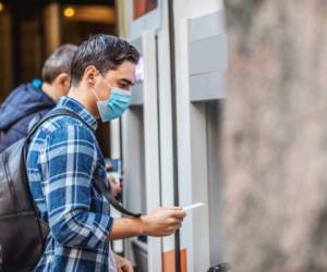 Concept, diseases, viruses, allergies, air pollution. Portrait of young man wearing a protective mask, walking in the city.The image face of a young man wearing a mask to prevent germs, toxic fumes, and dust. Prevention of bacterial infection Corona virus or Covid 19 in the air around the streets and gardens.