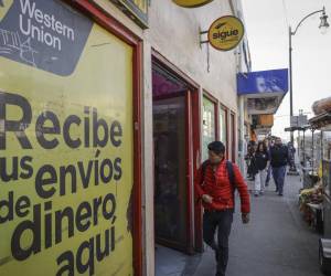 <i>Fotografía de archivo de una persona que camina frente a un establecimiento de envío de dinero en Tijuana (México). EFE/ Joebeth Terríquez</i>