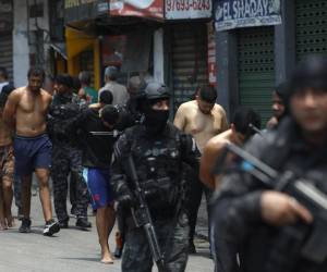 <i>Integrantes de la Policía de Río de Janeiro trasladan a un grupo de personas durante un operativo este martes, en Río de Janeiro (Brasil). EFE/ Antonio Lacerda</i>
