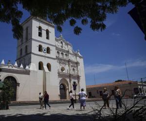 <i>Fotografía del 11 de abril de 2025 de personas caminando frente a la catedral de la Inmaculada Concepción en Comayagua (Honduras). En pleno corazón de Honduras, la ciudad de Comayagua guarda en lo alto un tesoro: un reloj en la torre del campanario que muchos aseguran ser el más antiguo de América, incluso del mundo, mientras que otros historiadores dudan de esos datos ante la falta de documentos que lo verifican. EFE/ Bienvenido Velasco</i>