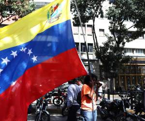 <i>Un simpatizante del oficialismo sostiene una bandera de Venezuela este sábado en inmediaciones del Palacio de Miraflores en Caracas (Venezuela). Chavistas salieron a las calles del centro de Caracas para exigir que devuelvan al mandatario venezolano, Nicolás Maduro, luego de que el líder estadounidense, Donald Trump, anunciara la captura del gobernante suramericano en medio de un ataque con misiles durante la madrugada de hoy contra la capital venezolana y otras zonas del país. EFE/ Miguel Gutiérrez</i>