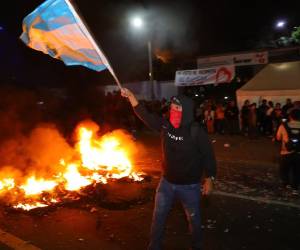 <i>Un hombre sostiene una bandera durante una manifestación este lunes, frente a las instalaciones del Instituto Nacional de Formación Profesional (Infop) en Tegucigalpa (Honduras). Militantes del oficialista Partido Libertad y Refundación (Libre, izquierda) de Honduras se manifestaron en las calles tras el llamado del expresidente Manuel Zelaya, quien, junto a la candidata Rixi Moncada, denunció un supuesto fraude en las elecciones. EFE/ Gustavo Amador</i>