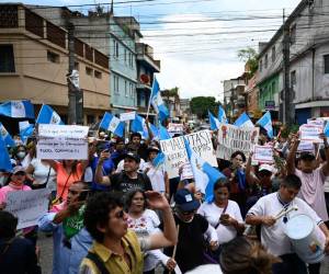 <i>La gente se manifiesta durante la “Marcha de las Flores” para exigir la renuncia de la procuradora general Consuelo Porras y otros funcionarios judiciales acusados de generar una crisis electoral en Guatemala antes de una segunda vuelta, frente a la sede del Ministerio Público en la ciudad de Guatemala el 23 de julio de 2023. Guatemala se ha visto sacudida durante semanas por acciones legales contra el partido Semilla de Bernardo Arévalo, uno de los dos candidatos presidenciales que emergerán de una primera ronda electoral el 25 de junio. FOTO Johan ORDONEZ / AFP</i>