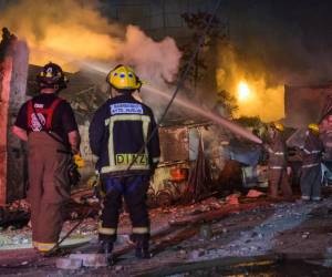 <i>Los bomberos trabajan para extinguir un incendio luego de una explosión en un establecimiento comercial en San Cristóbal, República Dominicana, el 14 de agosto de 2023. (Foto de AFP stringer / AFP)</i>