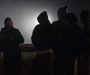 Salvadorean migrants traveling with the third Central American caravan to the United States, stand at the US-Mexico border in Playas de Tijuana, Baja California State, Mexico, late November 30, 2018. (Photo by Guillermo Arias / AFP)