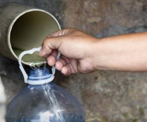 Una persona colecta agua potable de un tubo en St. James, un suburbio a a 25 km de Ciudad del Cabo.