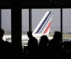 (FILES) In this file photo taken on September 16, 2014 people stand in bar at the Orly airport while a plane is parked on the tarmac, on the second day of the French company Air France pilots' strike. - Air France is to cut 1,500 jobs, mostly among ground staff, by the end of 2022, union sources told AFP on February 27, 2020, though the company declined to confirm the figures pending negotiations with labour representatives. (Photo by STEPHANE DE SAKUTIN / AFP)