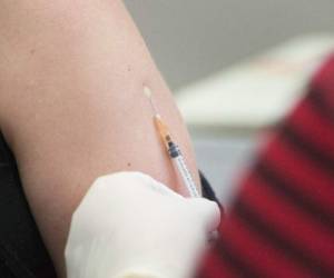 (FILES) In this file photo taken on May 04, 2020 a volunteer is injected with a syringe containing either the vaccine or a placebo, at the start of a clinical trial being set up by TASK, a clinical research organisation based in Cape Town, to see whether the Bacillus Calmette-Guerin (BCG) vaccine, which is given to babies in the country to protect them against tuberculosis, helps limit the damage caused by COVID-19, at a Hospital in Cape Town. - Orders for vaccines against diseases such as measles have declined since a national emergency was declared in the United States because of the coronavirus pandemic, the US Centers for Disease Control and Prevention said May 8, 2020. (Photo by RODGER BOSCH / AFP)