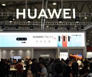 (FILES) This file photo taken on June 11, 2019 shows people gathering at a Huawei stand during the Consumer Electronics Show, Ces Asia 2019 in Shanghai. - Whether Beijing and Washington reach a trade deal or not, China is already speeding up efforts to break its reliance on a country that is both its most important economic partner and biggest adversary. The effort has gained greater urgency for Beijing after more than a year of protracted negotiations, painful tariffs and US sanctions against leading Chinese technology companies. (Photo by HECTOR RETAMAL / AFP) / China OUT / TO GO WITH CHINA-US-TRADE BY POORNIMA WEERASEKARA AND SEBASTIEN RICCI