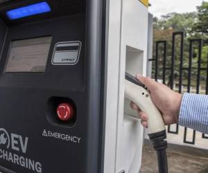 <i>ARCHIVO. El costarricense Roberto Quirós, propietario de dos autos eléctricos, carga uno de ellos en una estación de carga del Instituto Costarricense de Electricidad (ICE) en San José el 4 de diciembre de 2018. (Foto de Ezequiel BECERRA/AFP)</i>