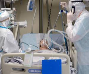 TOPSHOT - Medical workers wearing a personal protective equipment PPE tend to a patient infected with the Covid-19 at the intensive care unit of the Mariinsky Hospital in Saint Petersburg on July 7, 2021. - Russia on July 4, 2021 counted more than 25,000 new daily infections after a week of record death tolls as the highly contagious Delta variant propels a global resurgence of the pandemic. The coronavirus has killed nearly four million people worldwide, forcing numerous nations to reimpose restrictions well over a year after the outbreak of the pandemic. (Photo by Olga MALTSEVA / AFP)