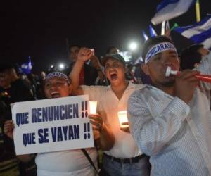 Students carry candles during a protest demanding Nicaraguan President Daniel Ortega and his wife, Vice President Rosario Murillo to step down, in Managua on April 27, 2018. / AFP PHOTO / RODRIGO ARANGUA