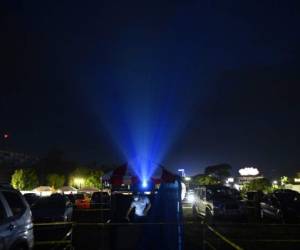 People sit in their cars to watch a movie in a drive-in cinema in San Salvador, on August 5, 2020, amid the novel coronavirus pandemic. (Photo by MARVIN RECINOS / AFP)