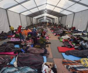 Central American migrants -mostly Hondurans- taking part in a caravan to the US, rest during a stop at a temporary shelter in a sports center, in Mexico City where they expect to ask for a permit to continue travelling through Mexican territory, on November 6, 2018. - Some 4,000 migrants en route to US recover energy Monday in a shelter in Mexico City, where they await the arrival of thousands more. US President Donald Trump warned that up to 15,000 soldiers could be deployed in the border with Mexico to stop the migrants' attempt to cross illegally into the country. (Photo by ALFREDO ESTRELLA / AFP)